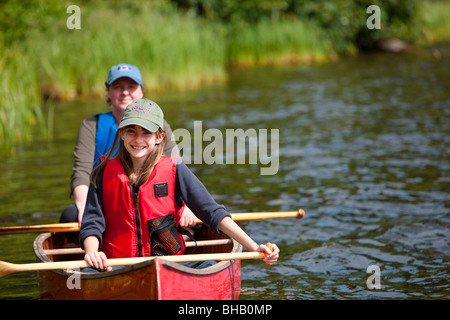 Mother and daughter paddling a canoe together on Byers Lake, Summer, Denali State Park, Southcentral Alaska, USA. Stock Photo