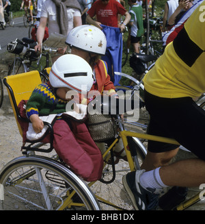 Two young children in a child carrier on the back of a bicycle Stock Photo