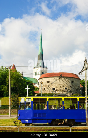 Tram in Tallinn, Estonia. Behind are the tower called Paks Margareta (Fat Margaret) and the 124m tall spire of St Olav’s church Stock Photo