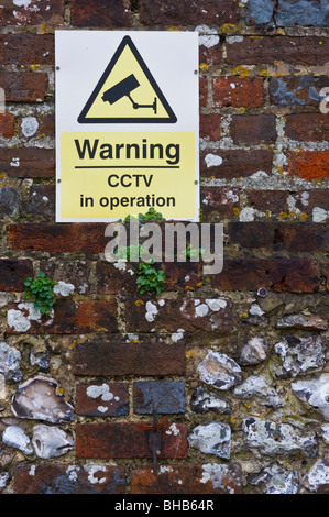 CCTV sign on a brick wall in a West Wycombe car park Buckinghamshire UK Stock Photo