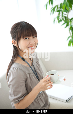 Japan, Osaka Prefecture, Businesswoman holding coffee cup, Portrait Stock Photo