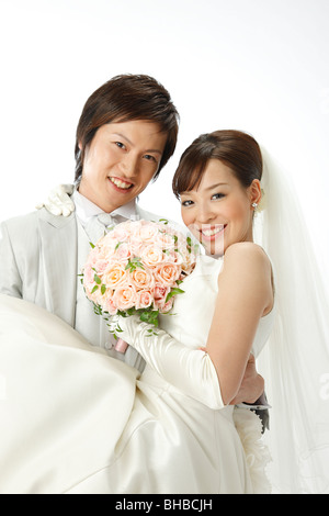 portrait of smiling groom carrying bride Stock Photo
