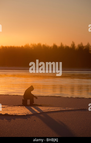 Ice-fishing at Oulujoki river Finland Stock Photo