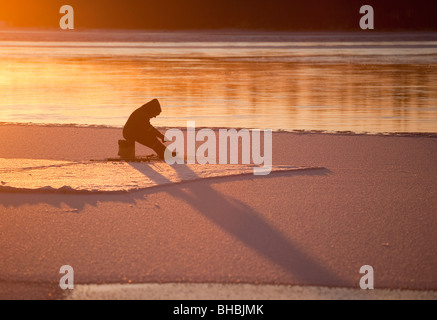 Ice-fishing at Oulujoki river Finland Stock Photo