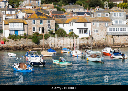 Rowing across the harbour in the old fishing village of Mousehole, Cornwall Stock Photo