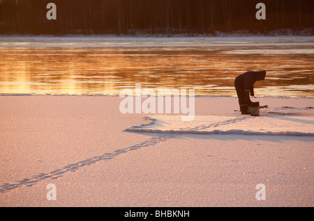 Ice-fishing at Oulujoki river Finland Stock Photo