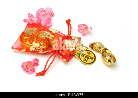 Chinese new year gold ingots and coins in red sachet on white background Stock Photo