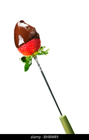 Strawberry dipped in delicious chocolate on fondue skewer Stock Photo