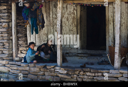 A NEPALI GRANDMOTHER and GRANDCHILD on their front porch - AROUND MANASLU TREK, NEPAL Stock Photo