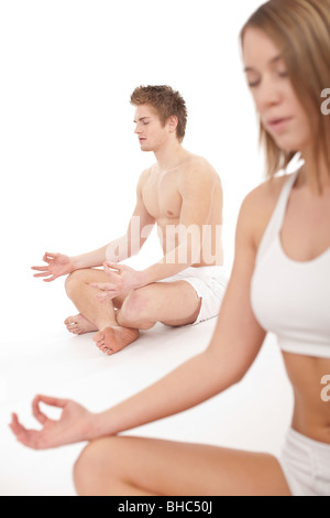 Fitness - Healthy couple stretching in yoga position on white background Stock Photo