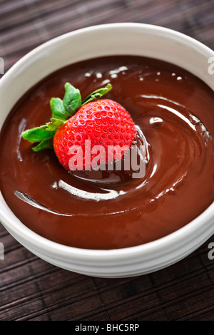 Fresh strawberry dipped in melted chocolate in bowl Stock Photo