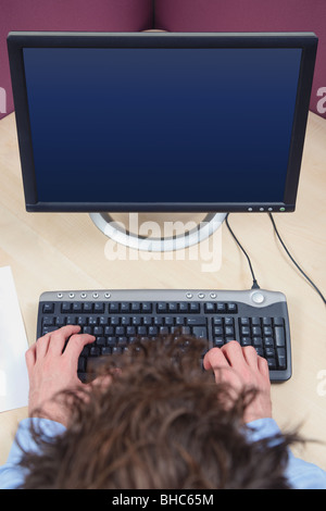A man working on a computer, overhead shot, blank screen with clipping path to add your own image. Stock Photo