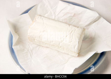 French Goats Cheese on Paper and a Blue Plate Stock Photo