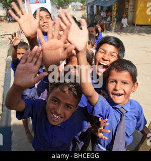 Indian school children laughing and waving in an Indian village, Rajasthan, India