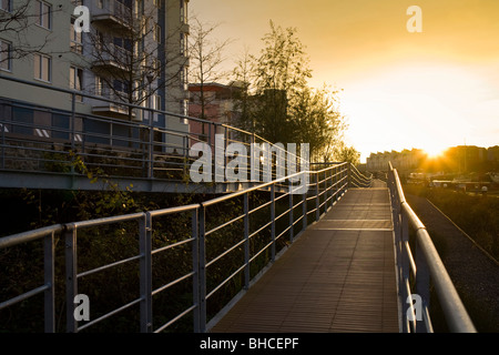 Walkway alongside new housing developements in Bristol harbour with sunset Stock Photo