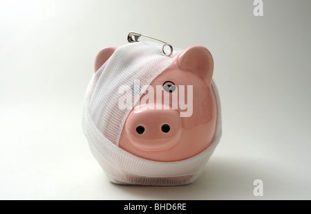 BANDAGED/INJURED PIGGYBANK WITH SAFETY PIN RE FINANCE LOANS CASH MONEY SAVINGS PIGGY BANK BANKS MORTGAGES INCOMES WAGES UK ETC Stock Photo