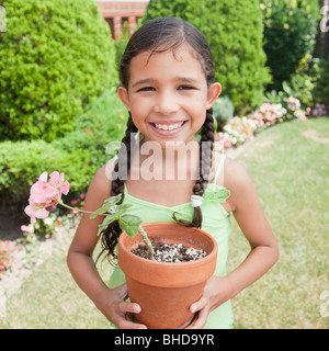 Hispanic girl holding potted plant Stock Photo