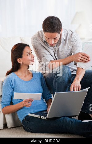 Hispanic couple paying bills online
