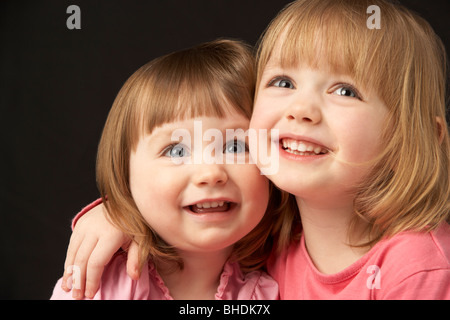 Studio Portrait Of Two Sisters Stock Photo