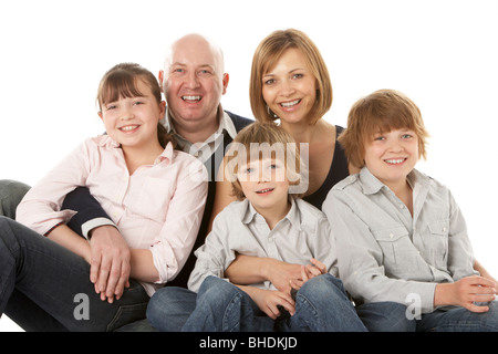 Studio Shot Of Family Group Sitting In Studio Stock Photo
