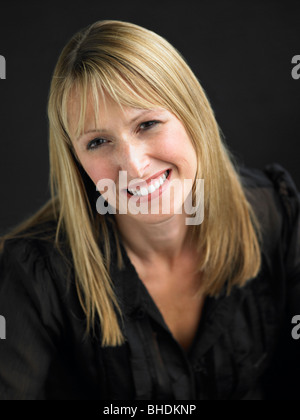 Studio Portrait Of Young Woman Against Black Background Stock Photo