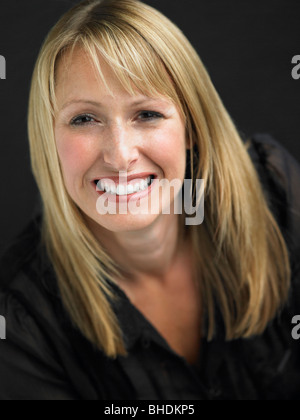 Studio Portrait Of Young Woman Against Black Background Stock Photo
