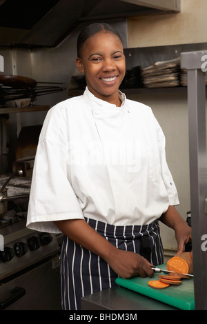 Female Chef Preparing Vegetables In Restaurant Kitchen Stock Photo