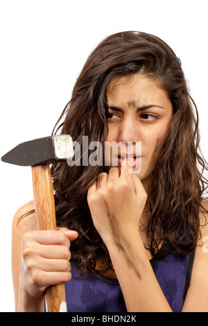 Young lady angry and in pain after hitting herself with the hammer in a finger Stock Photo