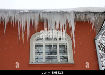 Large icicles hanging from a gutter on a house in Tallinn, Estonia. Stock Photo