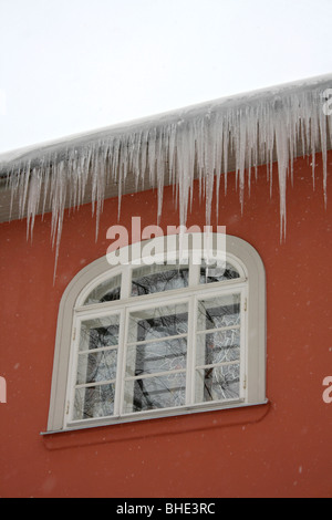 Large icicles hanging from a gutter on a house in Tallinn, Estonia. Stock Photo
