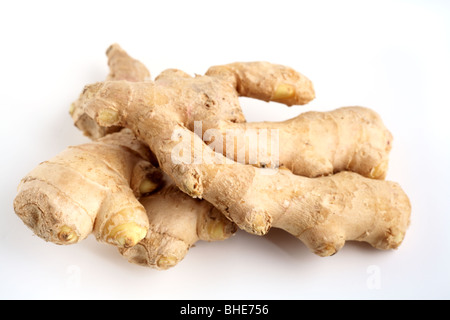 Two pieces of fresh root ginger viewed from the side against a white background Stock Photo