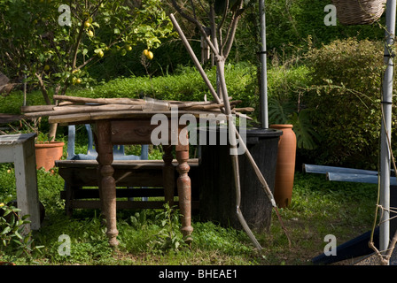 an arbor in a garden with tools and tables under it Stock Photo