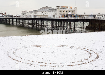 A circle withing a circle among snow on Brighton Beach, in front of the famous Brighton Pier, in East Sussex, England. Stock Photo