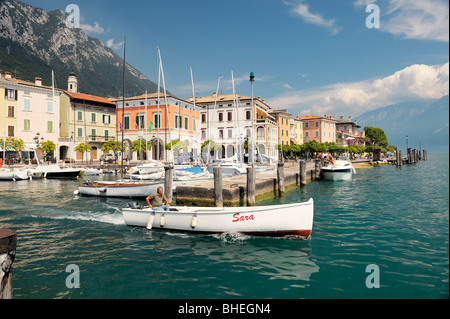The holiday resort town of Gargnano on Lake Garda, Lombardy, Italy. Boat leaving the harbour. Lago di Garda. Stock Photo