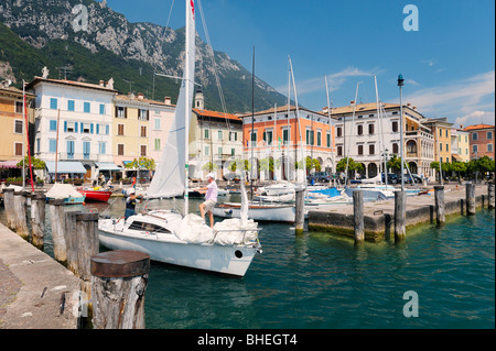 The holiday resort town of Gargnano on Lake Garda, Lombardy, Italy. Sail boat leaving the harbour. Lago di Garda. Stock Photo