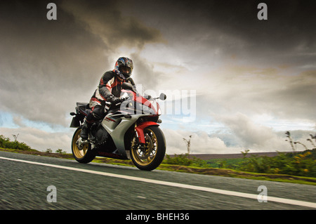 Side view of motorcyclist on the road crossing the North Yorkshire Moors, UK Stock Photo