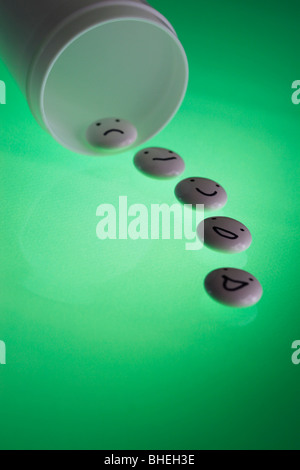 White tablets with mood faces on green background Stock Photo