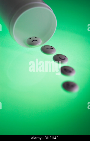 White tablets with mood faces on green background Stock Photo