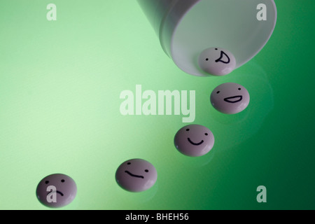 White tablets with mood faces on green background Stock Photo