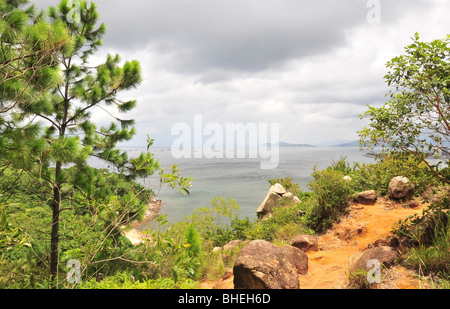 Sunny South China Sea view, pine tree, red soil, granite rocks on the cliff top, near Ling So Shing, Lamma Island, Hong Kong Stock Photo