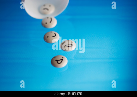 White tablets with mood faces on blue background Stock Photo