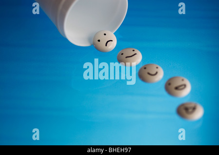 White tablets with mood faces on blue background Stock Photo