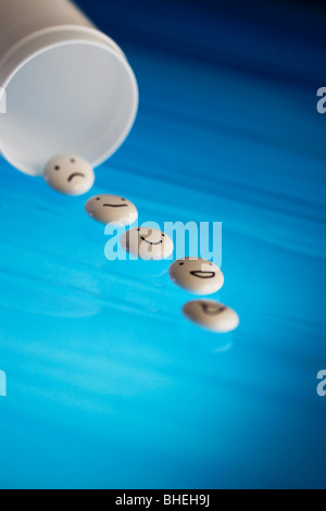 White tablets with mood faces on blue background Stock Photo