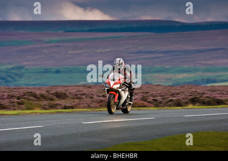 Motorcyclist wearing protective leathers on road in the North Yorkshire Moors, UK Stock Photo