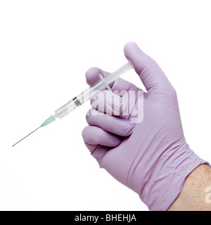 Purple latex free nitrile gloved male hand holding hypodermic needle, isolated against white background. Stock Photo