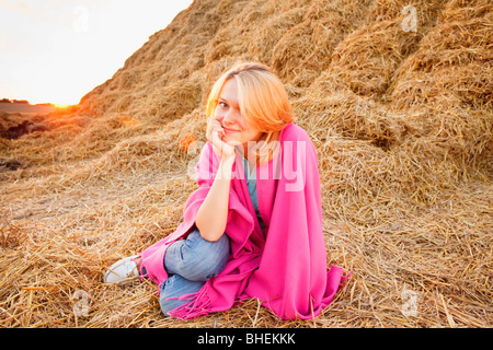 Young woman against hay bale Stock Photo