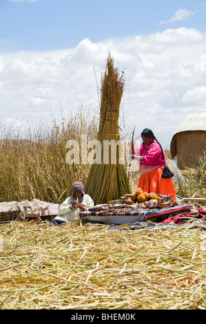 A woman and boy by their handicraft display on the Island of Samary, Uros Islands, Lake Titicaca, Peru Stock Photo