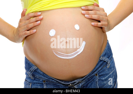 Pregnant woman shows a smiley on her belly Stock Photo