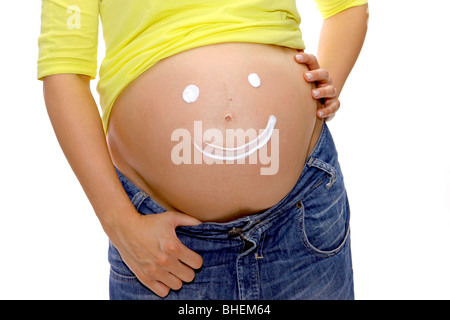 Pregnant woman shows a smiley on her belly Stock Photo