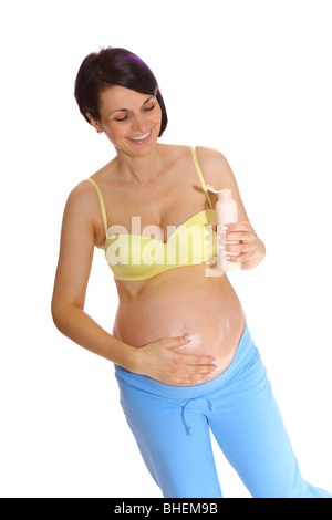 Pregnant woman putting cream on her belly to prevent stretch marks Stock Photo